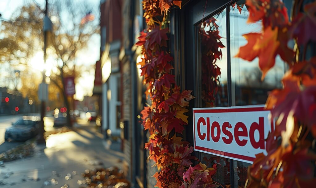 Closed sign on lawyer's office door with autumn leaves in urban setting, during sunset.